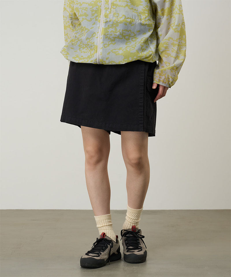 Model wearing a Gramicci G-Skort in the color black and a yellow patterned jacket on a light-tone background.