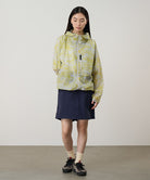 Model wearing a Gramicci G-Skort in the color double navy and a yellow patterned jacket on a light-tone background.