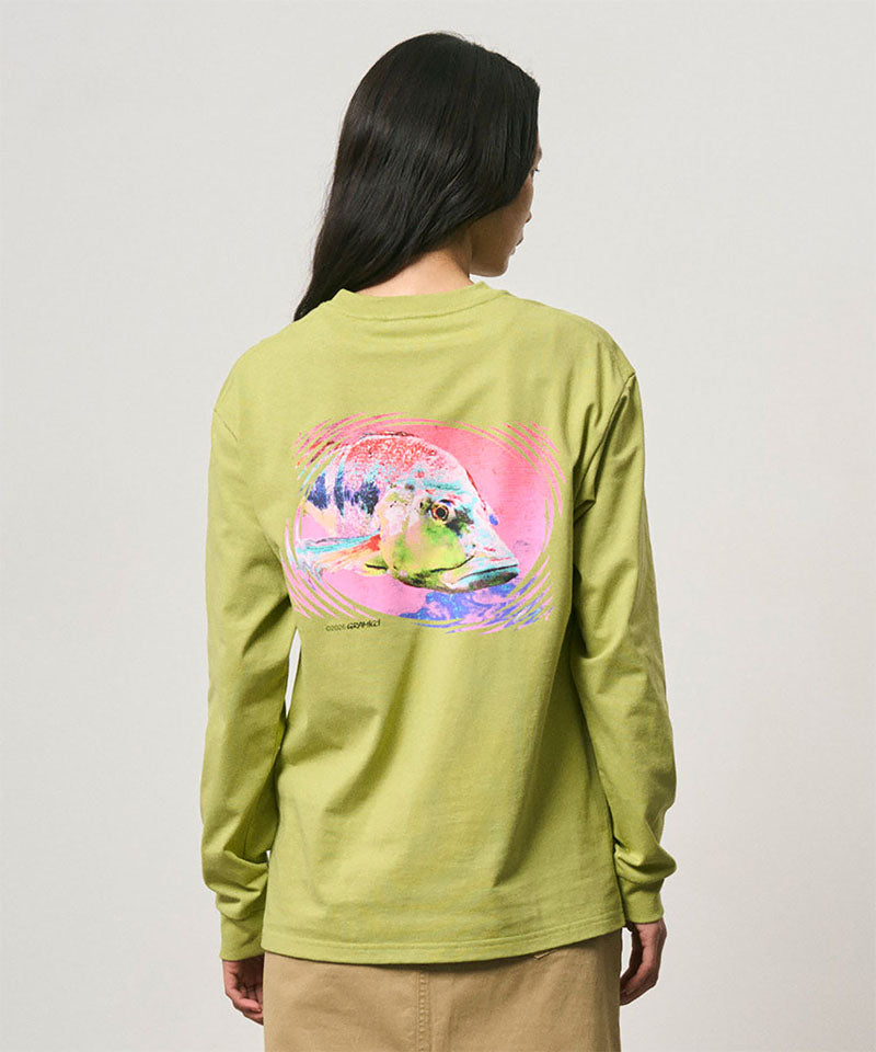 Back view of a model wearing a Gramicci sweet pea colored Bass Long-Sleeve Tee with a graphic against a light-tone background.