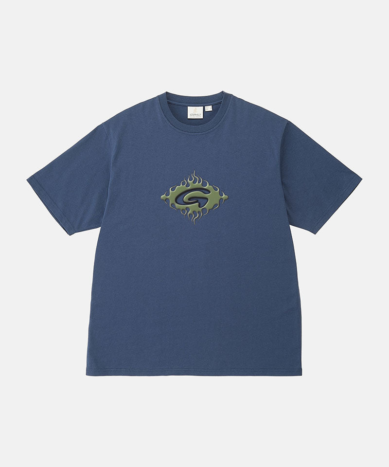 Model wearing a Gramicci navy Flames Tee with a graphic against a light-tone background.