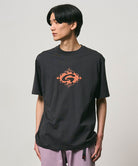 Model wearing a Gramicci vintage black Flames Tee with a graphic against a light-tone background.