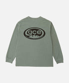 Back view of a Gramicci sage pigment colored GCE Long Sleeve Tee Pigment Dyed with a graphic against a light-tone background.
