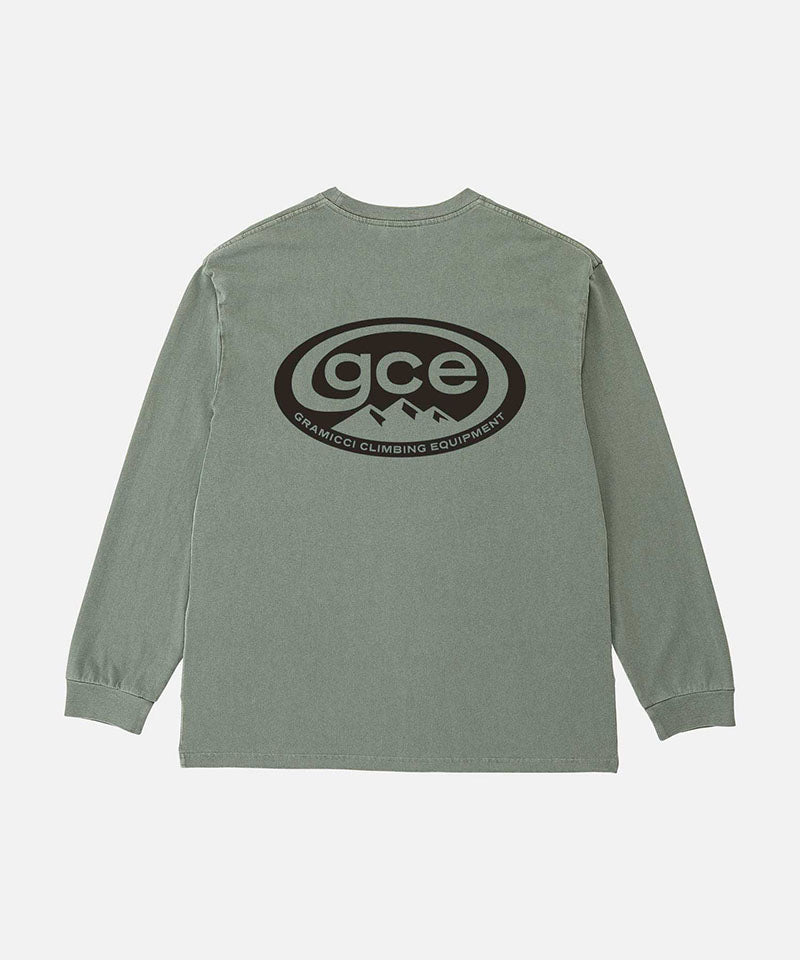 Back view of a Gramicci sage pigment colored GCE Long Sleeve Tee Pigment Dyed with a graphic against a light-tone background.