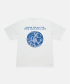 Back view of a Gramicci sage pigment colored Earth Tee with blue graphic against a light-tone background.