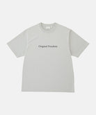 Gramicci mist colored Vase Tee against a light-tone background.