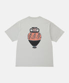 Back view of a Gramicci mist colored Vase Tee with a graphic against a light-tone background.