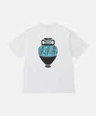 Back view of a Gramicci white Vase Tee with a graphic against a light-tone background.