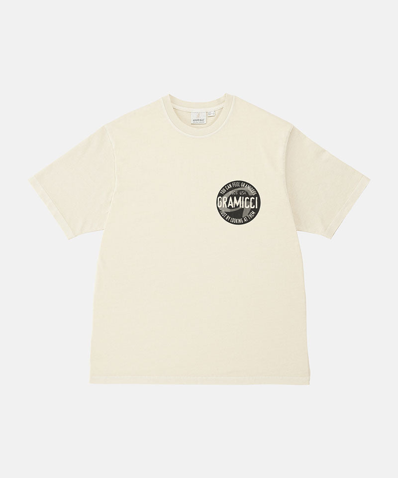 Gramicci natural pigment colored Icon Tee Pigment Dyed with a graphic against a light-tone background.