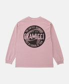 Back view of a Gramicci lilac pigment colored Icon Long Sleeve Tee Pigment Dyed with a graphic against a light-tone background.