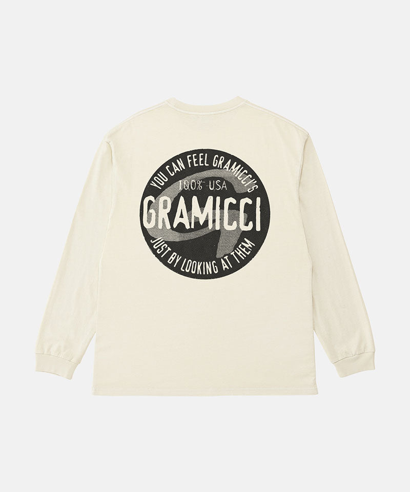 Back view of a Gramicci natural pigment colored Icon Long Sleeve Tee Pigment Dyed with a graphic against a light-tone background.
