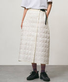Model wearing a frost colored Gramicci G-Zero Primaloft Skirt and a white shirt on a light-tone background.