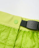 Close-up view of a lime colored Gramicci G-Zero Primaloft Skirt against a light-tone background.