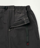 Close-up of the waistband on a black Gramicci women's Gramicci WR Convertible Skirt on a light-tone background.