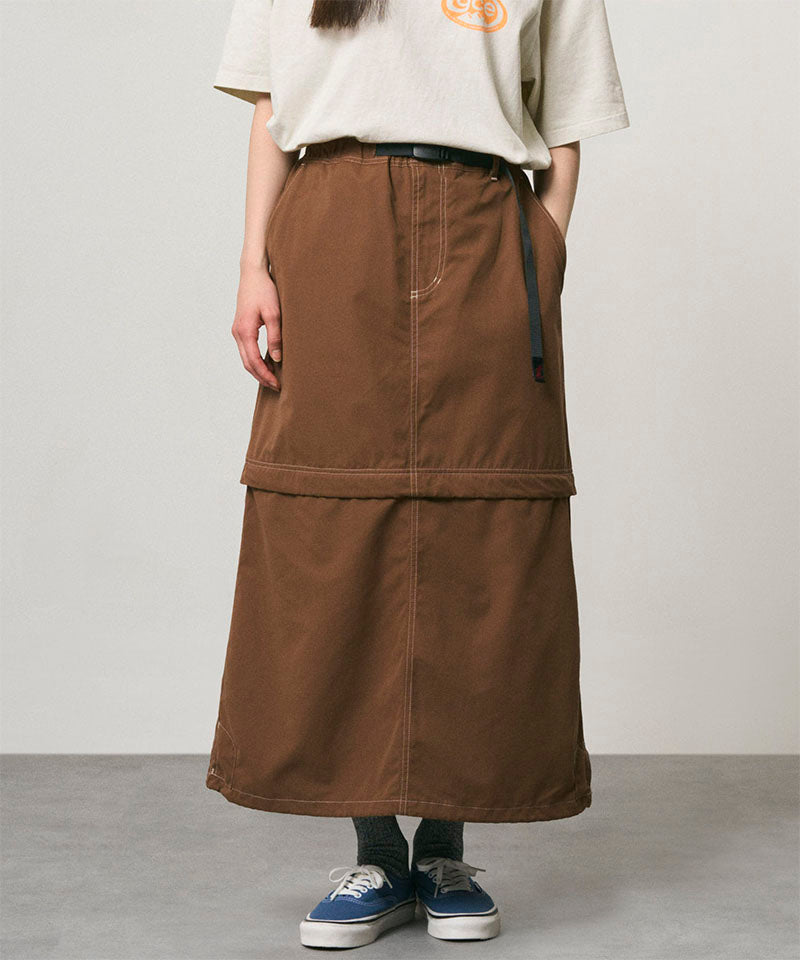 Model wearing a deep brown women's Gramicci WR Convertible Skirt and a creme colored shirt on a light-tone background.