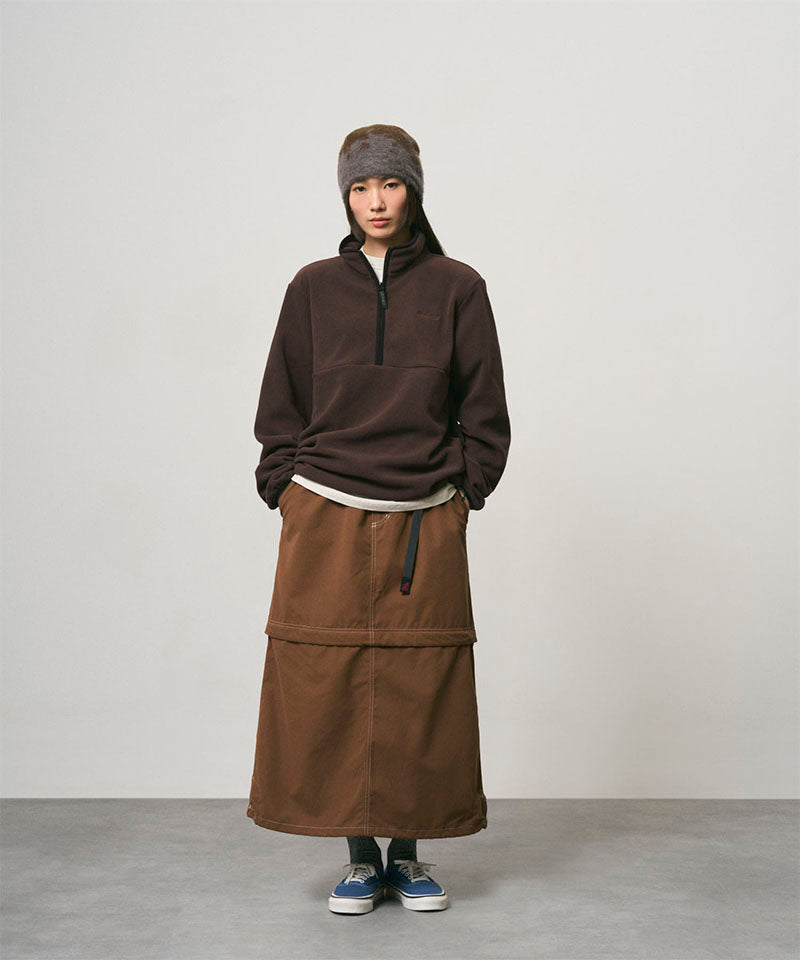 Model wearing a deep brown women's Gramicci WR Convertible Skirt and a dark brown shirt on a light-tone background.