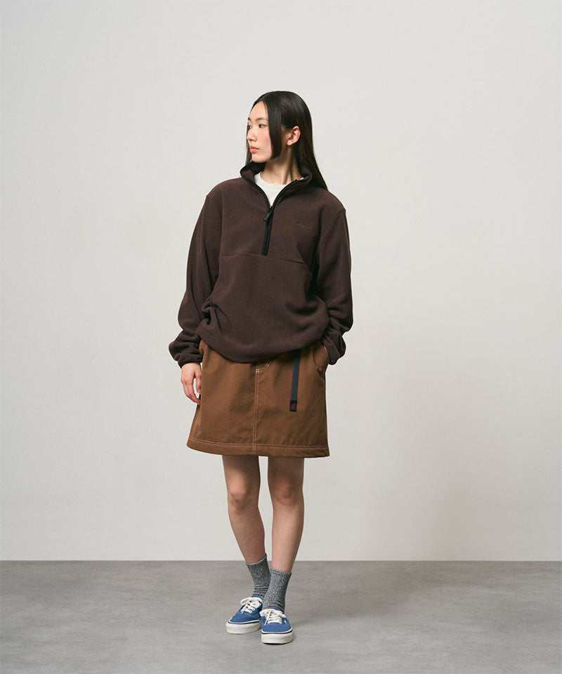 Model wearing a deep brown women's Gramicci WR Convertible Skirt and a dark brown jacket on a light-tone background.