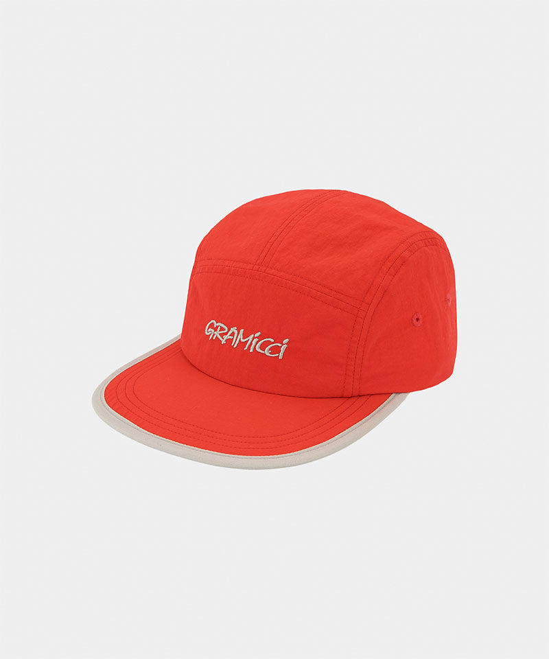 Burnt orange Nylon Gramicci Cap
with a light grey 'Gramicci' logo on a light tone background.