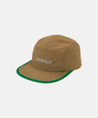 Coyote brown colored Nylon Gramicci Cap with a logo and a green brim on a light tone background.