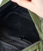 Close-up of Gramicci Field Sacoche bag in the color olive with a black interior.