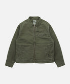 Gramicci moss green Taos Canvas Jacket against a light-tone background.