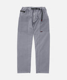 Gramicci natural dyed grey Gadget Pants with a black belt against a light-tone background.
