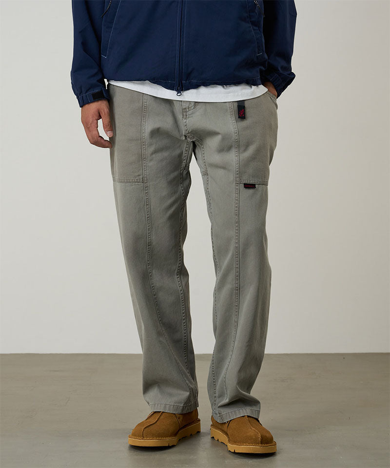 Model wearing a Gramicci natural dyed olive Gadget Pants against a light-tone background.
