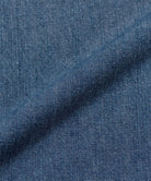 Close-up of Gramicci Japanese Chambray Double Knee pant blue denim fabric with a subtle pattern.