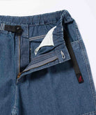 Close-up of the blue Gramicci Japanese Chambray Double Knee pant showing the zIp fly and belt on a light tone background.
