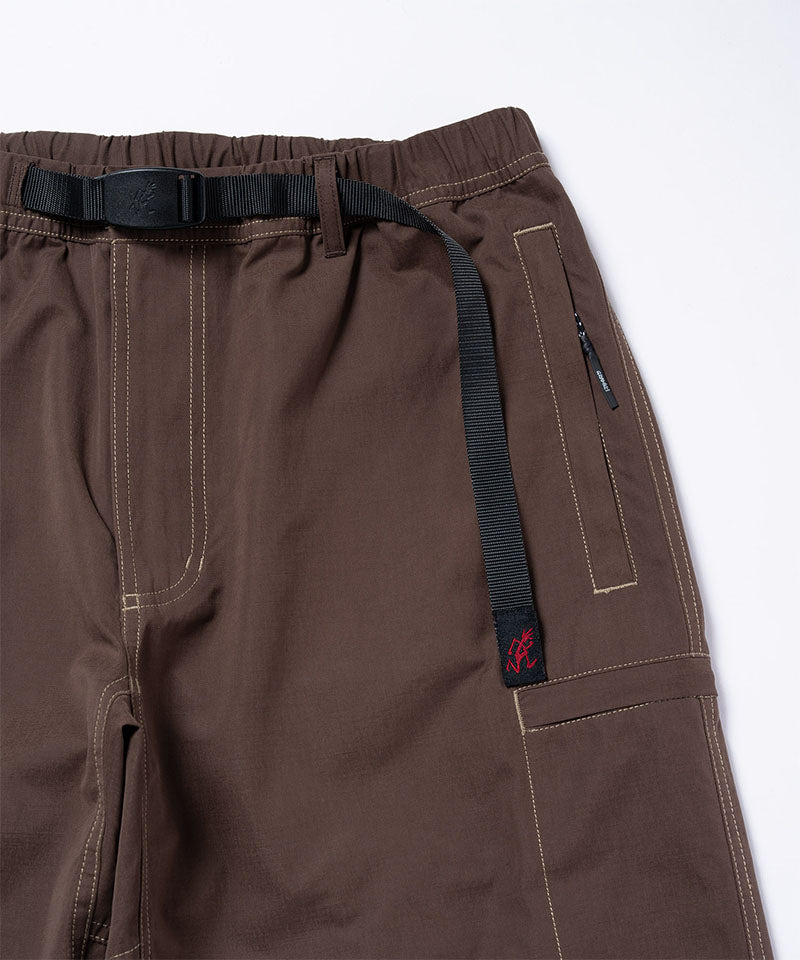 Close-up of Gramicci Milton Pants in the color walnut with a black belt against a light-tone background.