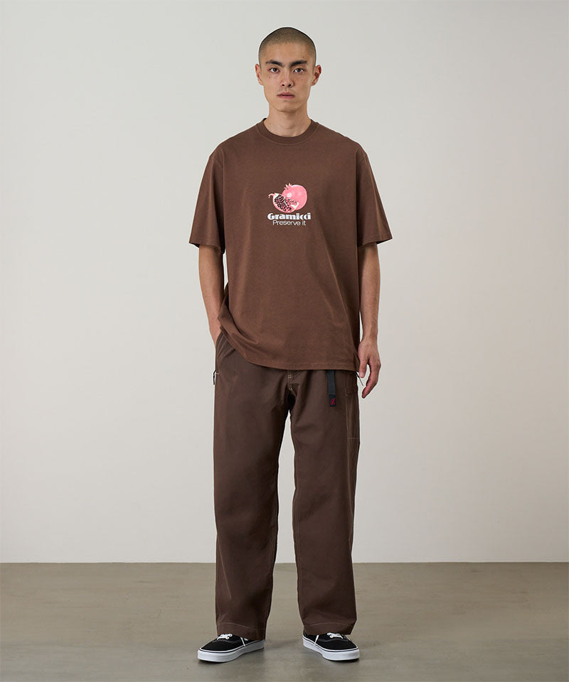 Model wearing walnut Gramicci Milton Pants and a brown shirt on a light-tone background.
