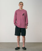 Person wearing a red long-sleeve shirt and black shorts against a plain background