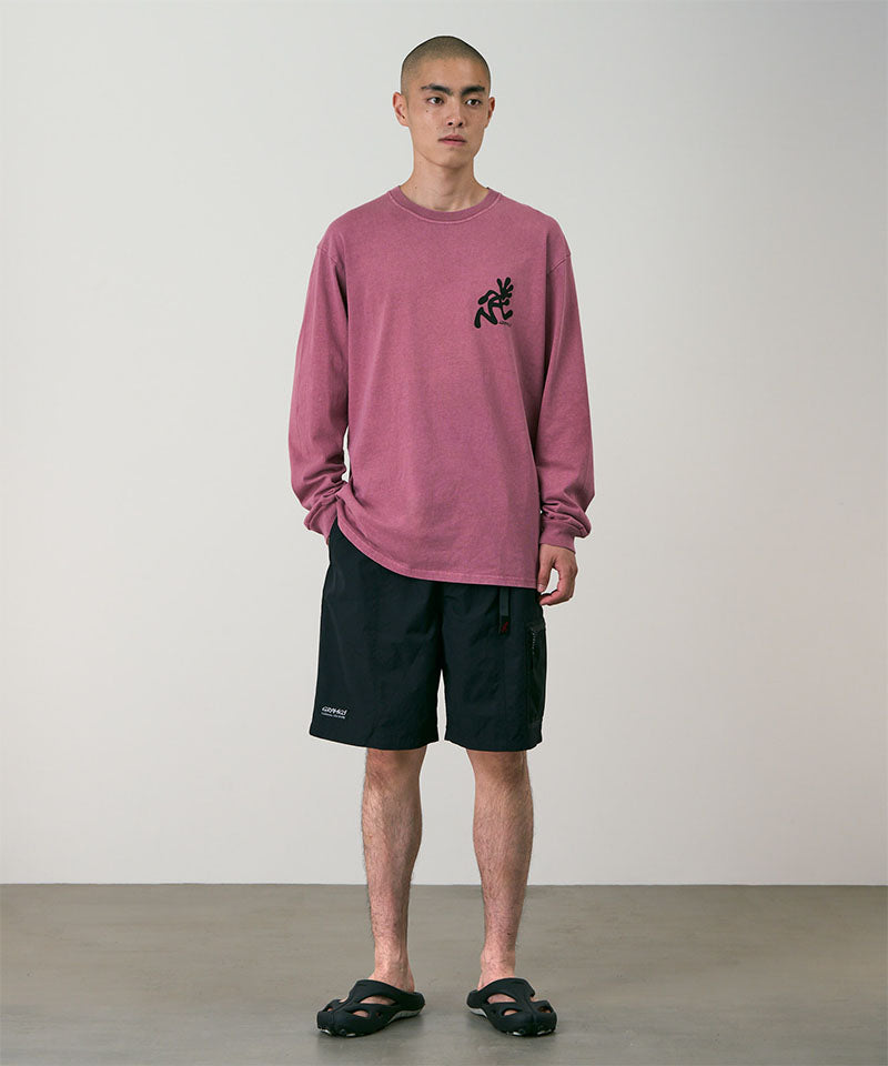 Person wearing a red long-sleeve shirt and black shorts against a plain background