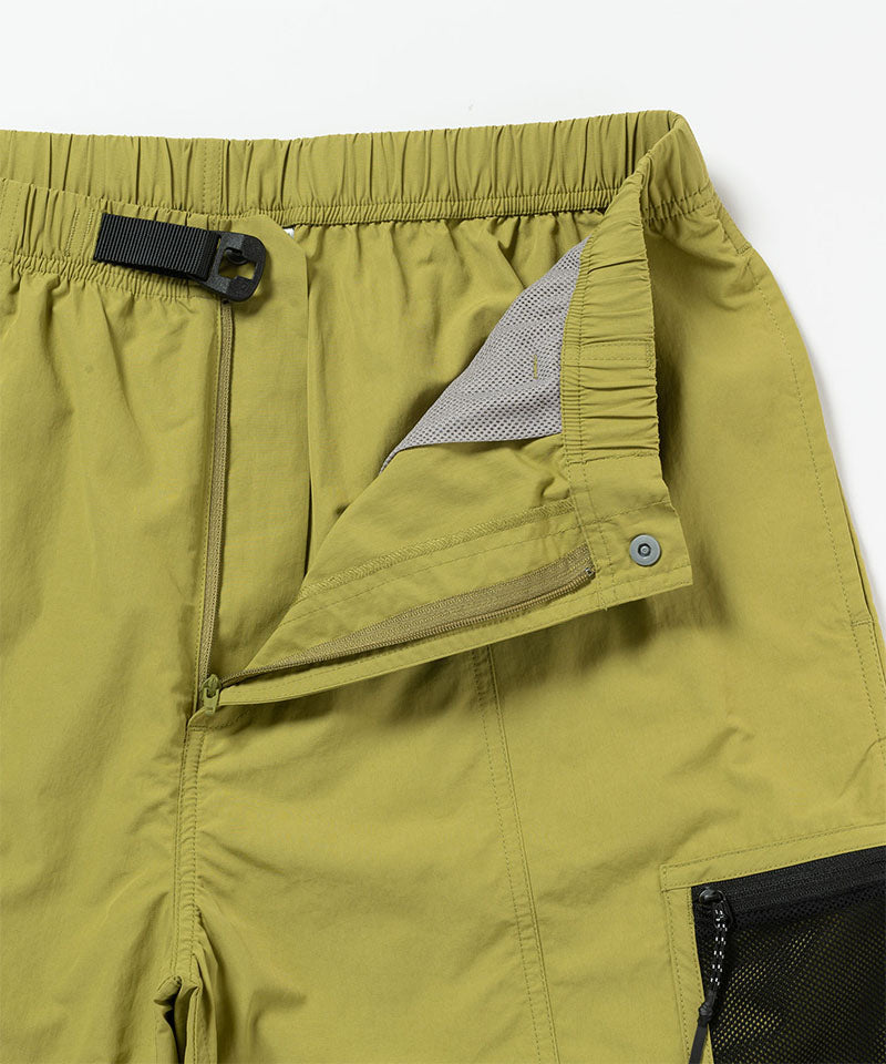 Close-up of green shorts with a zipper and pocket on a white background