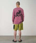 Person wearing a red long-sleeve shirt with a black graphic on the back, standing against a plain background.