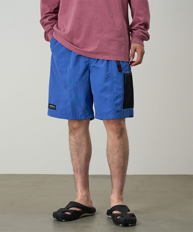 Person wearing blue shorts and a red shirt on a plain background