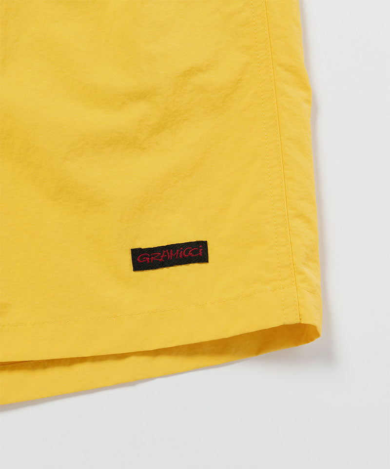 Yellow shorts with a brand logo on a white background