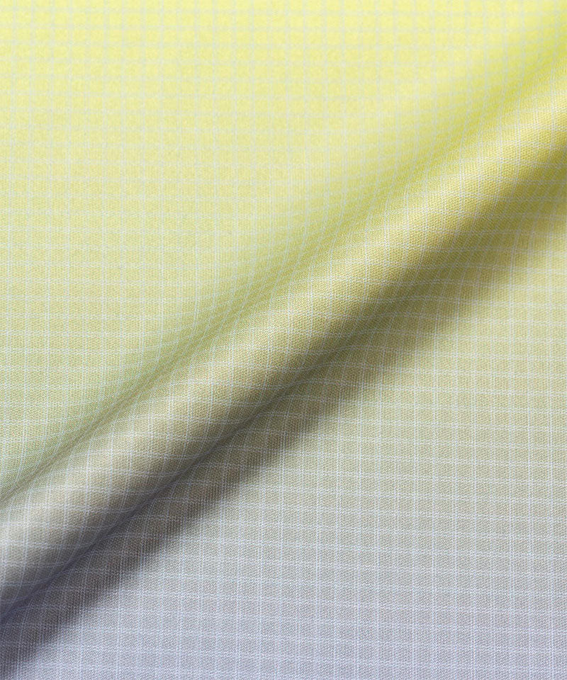 Close-up of a checkered fabric with a gradient from yellow to grey.