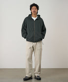 Model wearing the Gramicci Beach Hoodie Jacket in shadow with tan cargo pants on a light tone background.