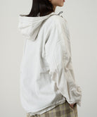Side view of a model wearing the Gramicci Beach Hoodie Jacket in stone on a light tone background.