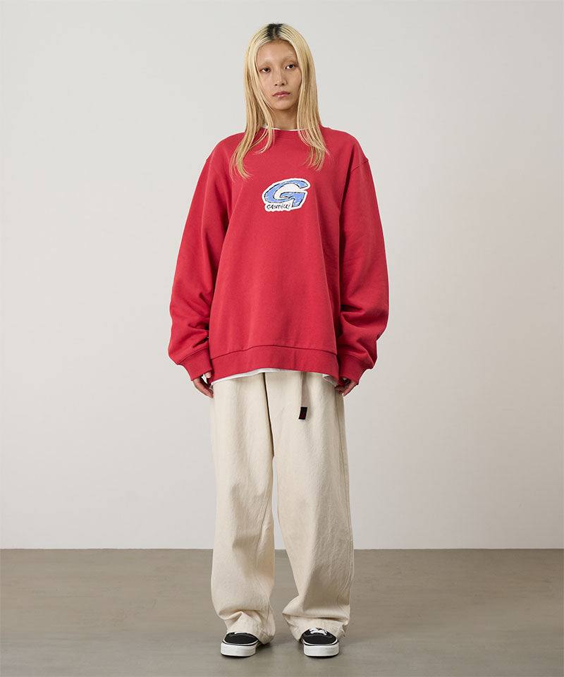 Person wearing a red sweatshirt with a logo, standing against a plain background