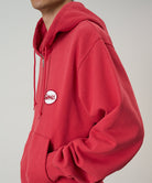 Red hoodie with a brand logo on a neutral background