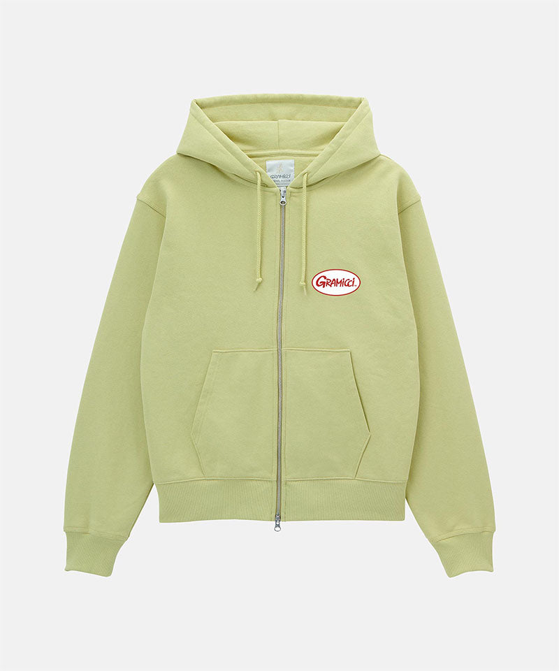Gramicci lime Oval Patch Zip Hooded Sweatshirt with a red and white patch against a light-tone background.