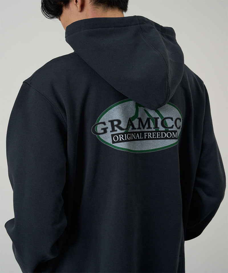 Person wearing a black hoodie with 'Gramicco Original Freedom' logo on the back against a gray background