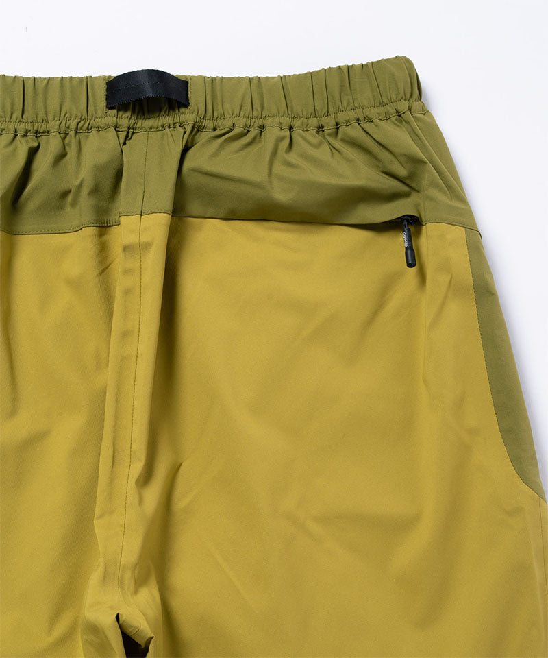 Olive yellow pants with green accents on a light tone background