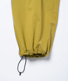Close-up of the adjustable hem drawstring on olive Gramicci DWR Field Pants