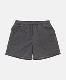 Front view of black Gramicci Grid Swim Shorts against a light tone background.
