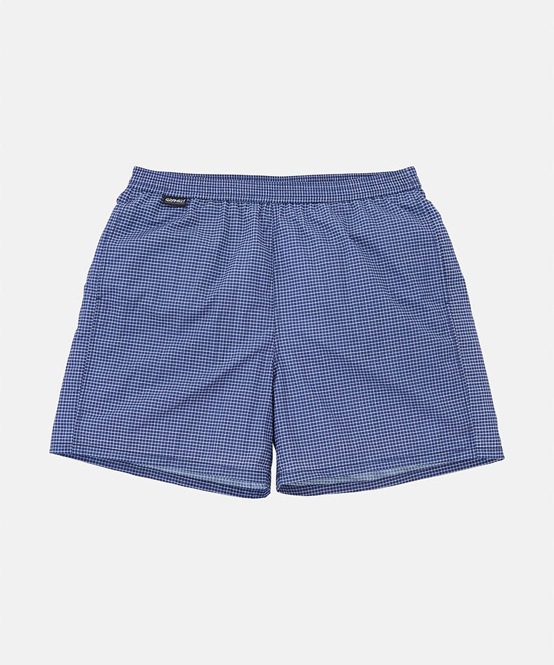 Front view of navy checkered Gramicci Grid Swim Shorts against a light-tone background.

