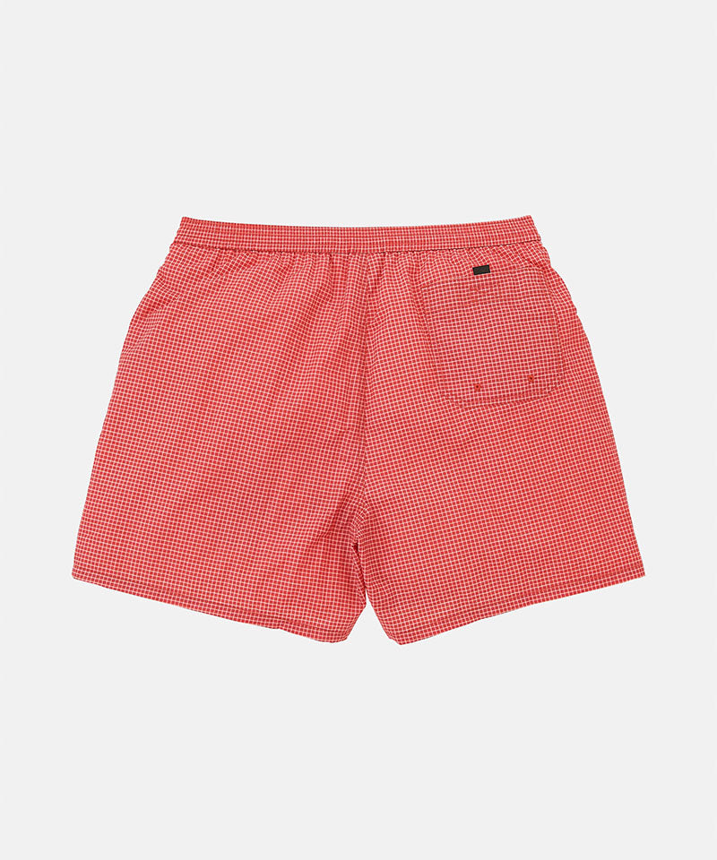 Back view of red checked Gramicci Grid Swim Shorts against a light-tone background.
