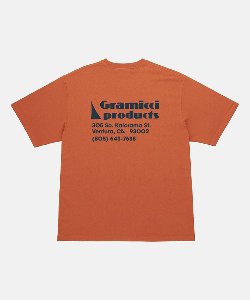 Back view of a Gramicci orange G-Sail Tee with black graphic against a light-tone background.