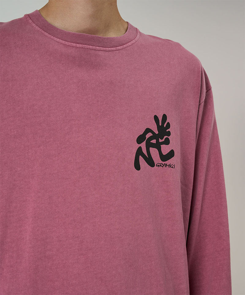 Model wearing a Gramicci red pigment Running Man L/S Tee Pigment Dyed with a black graphic against a light-tone background.